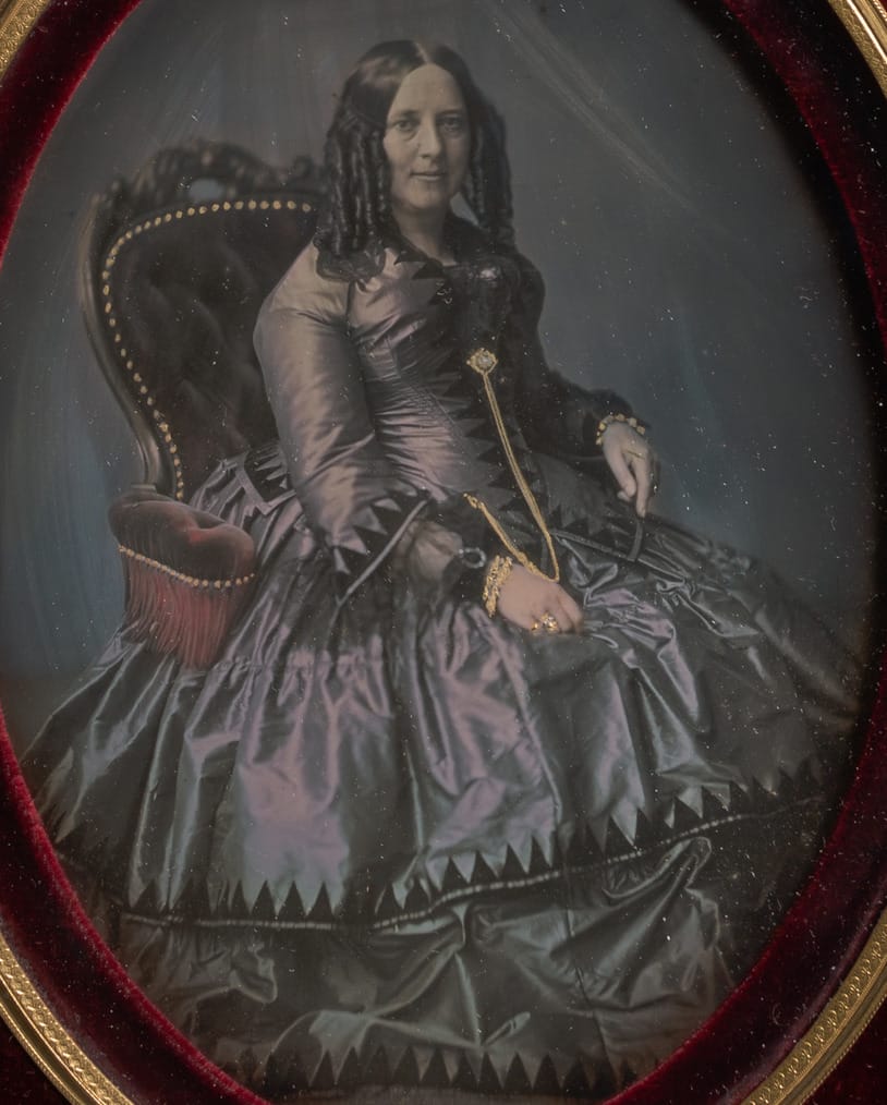 大都会博物馆藏的一张 1850 年代银版人像，缎面裙子，正襟危坐——她很可能十来年才拍这一次